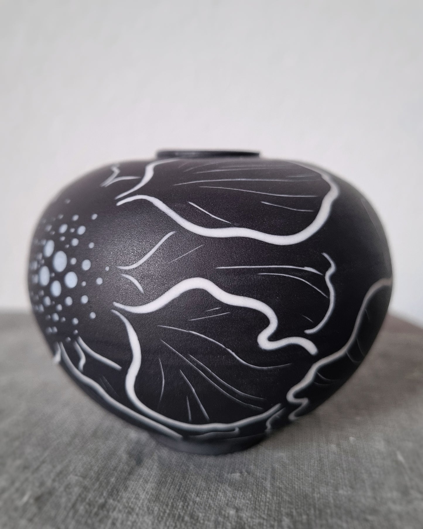 Petit vase en porcelaine noire et fleurs blanches