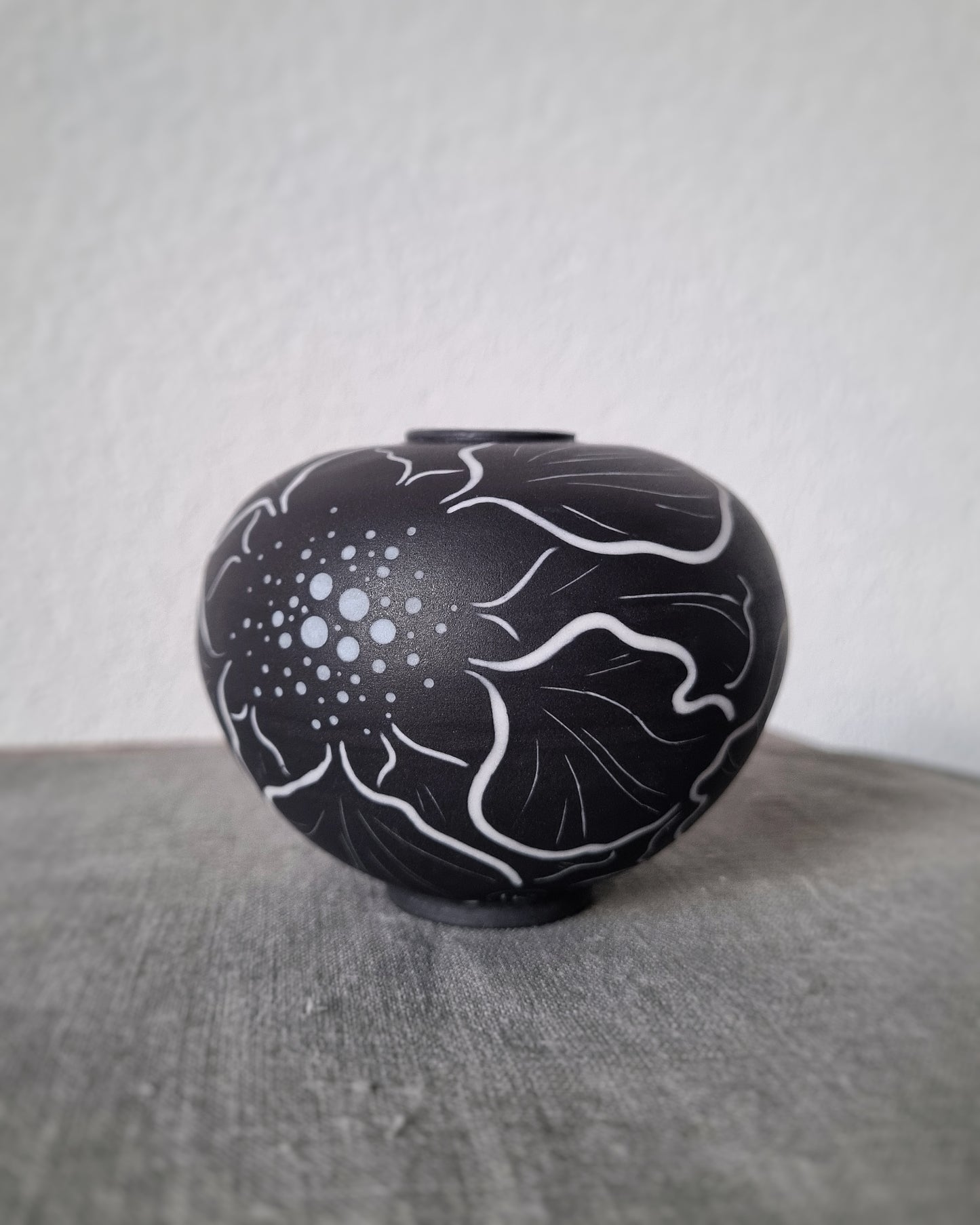 Petit vase en porcelaine noire et fleurs blanches