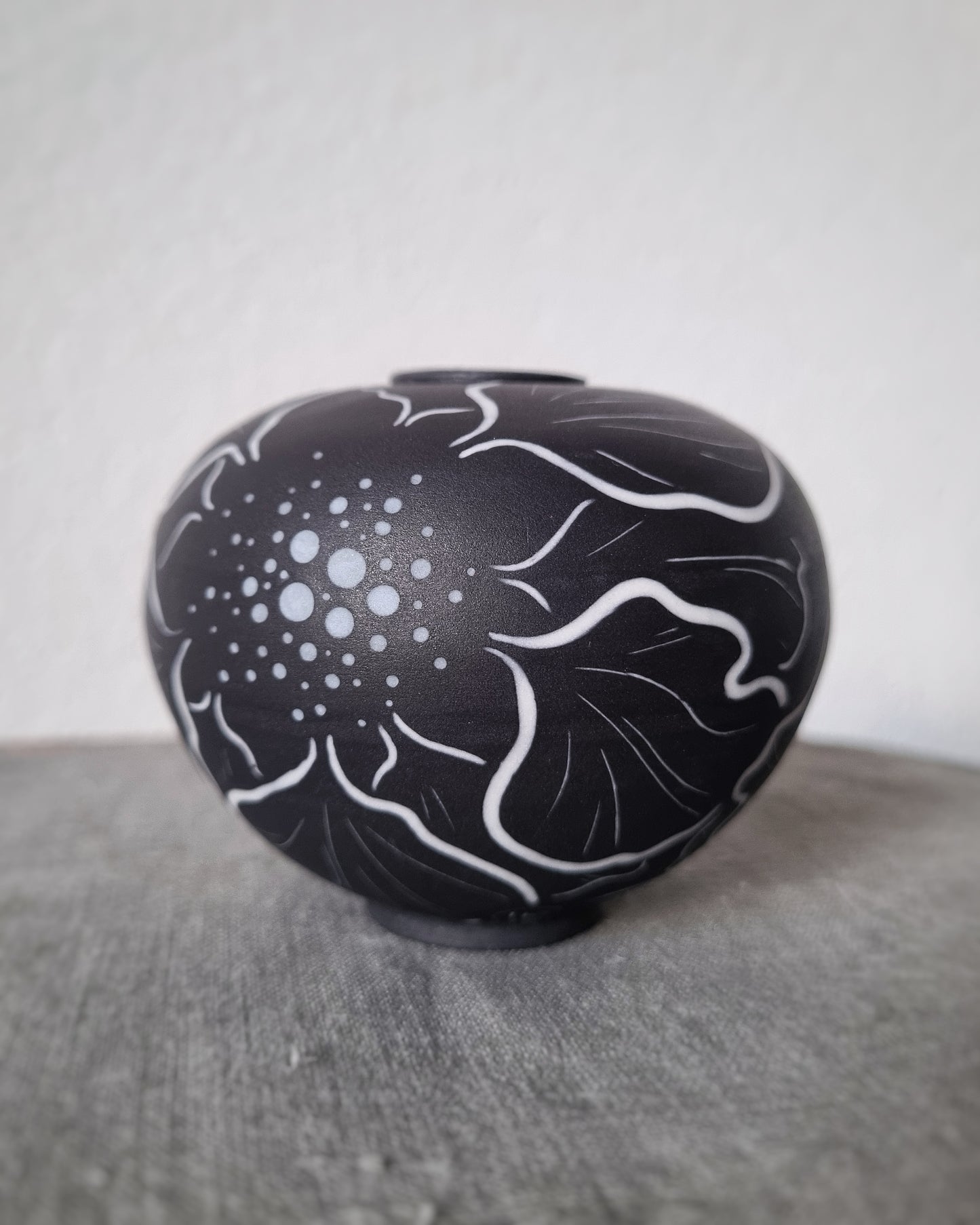 Petit vase en porcelaine noire et fleurs blanches