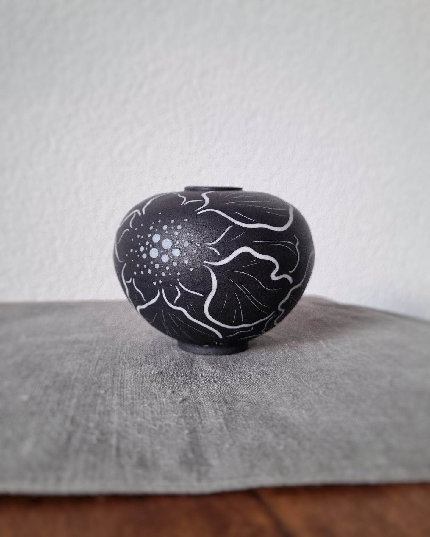 Petit vase en porcelaine noire et fleurs blanches