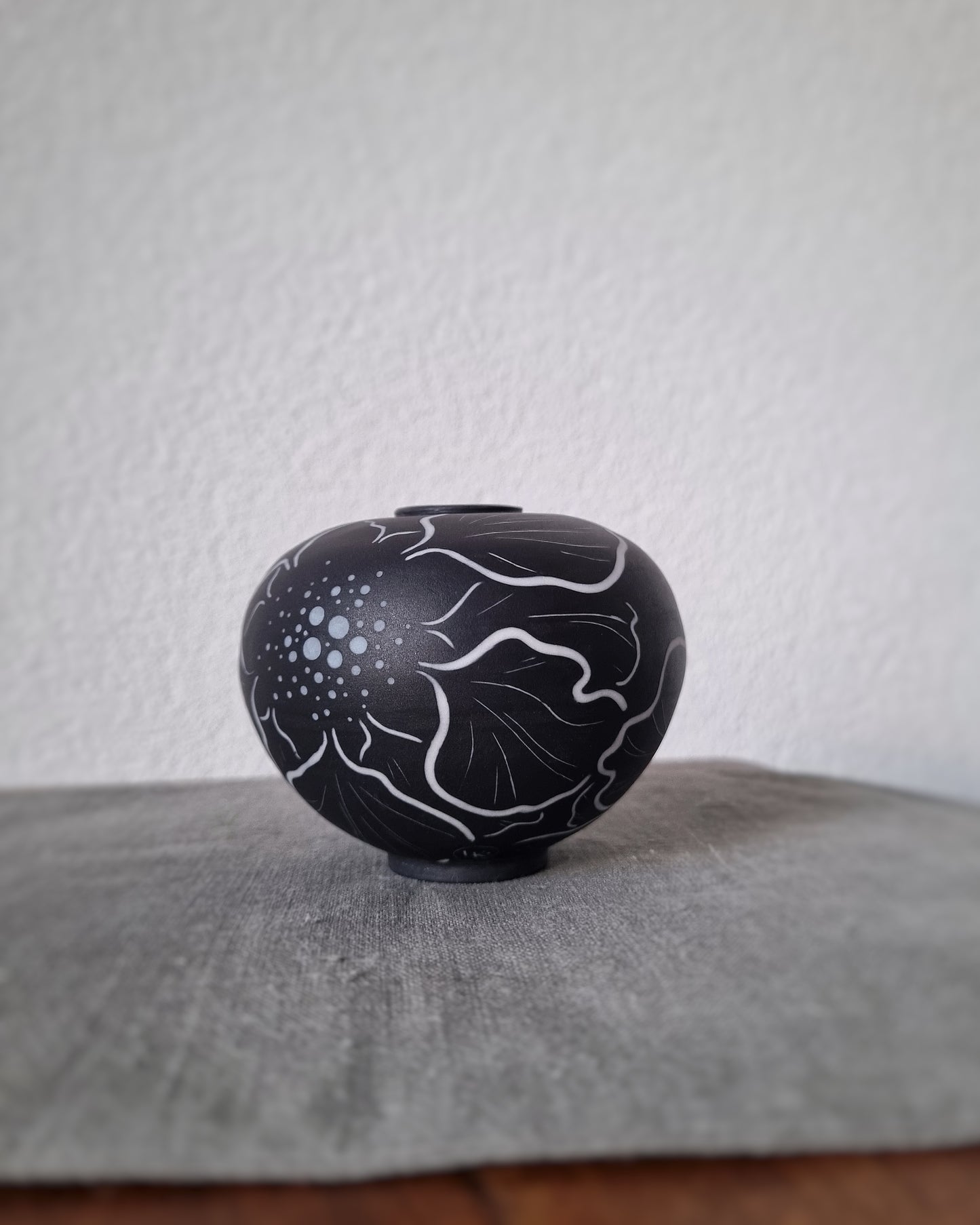 Petit vase en porcelaine noire et fleurs blanches