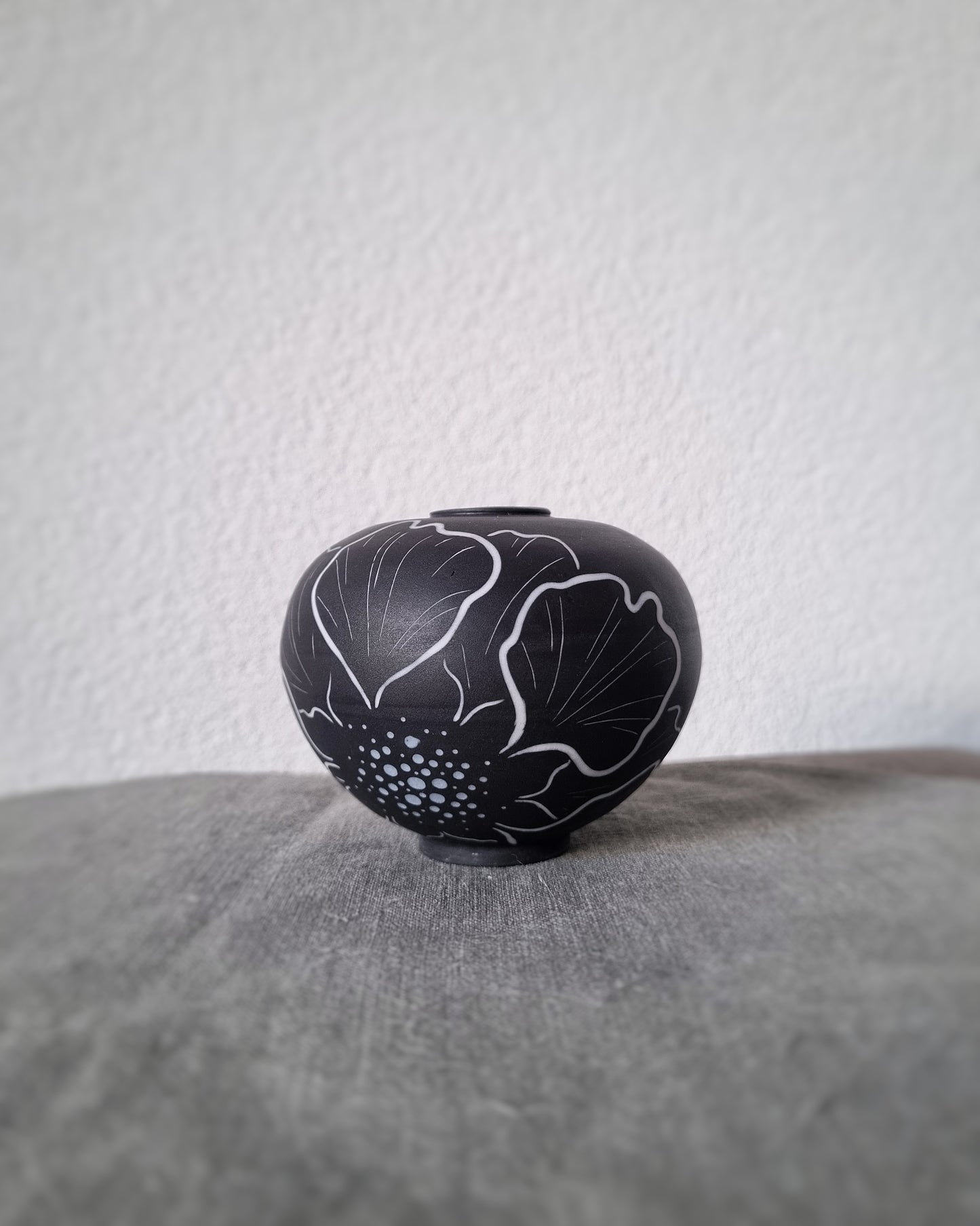 Petit vase en porcelaine noire et fleurs blanches