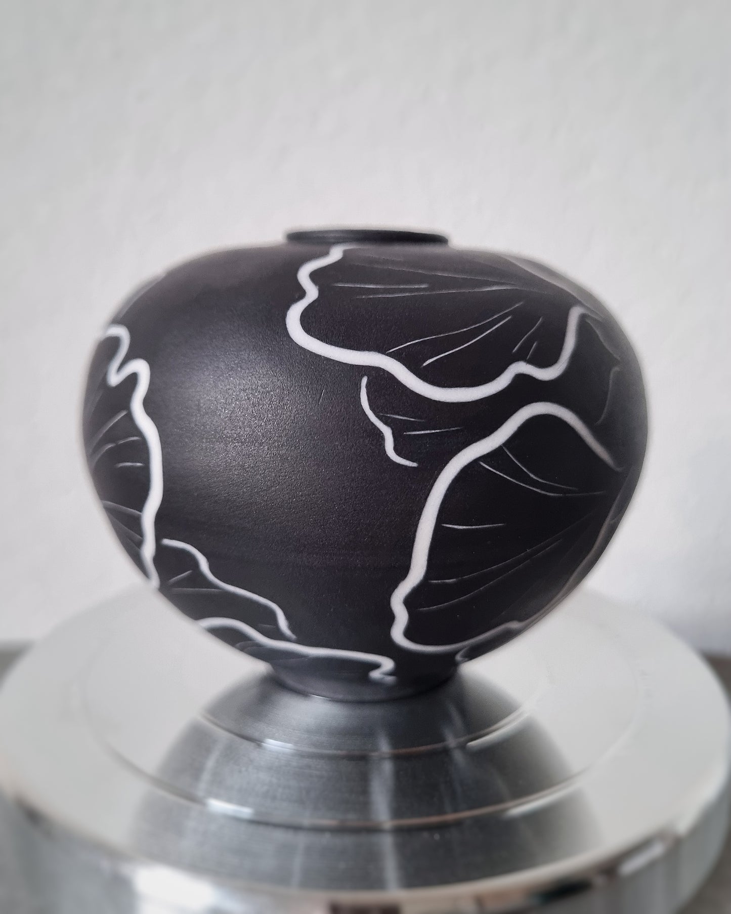 Petit vase en porcelaine noire et fleurs blanches