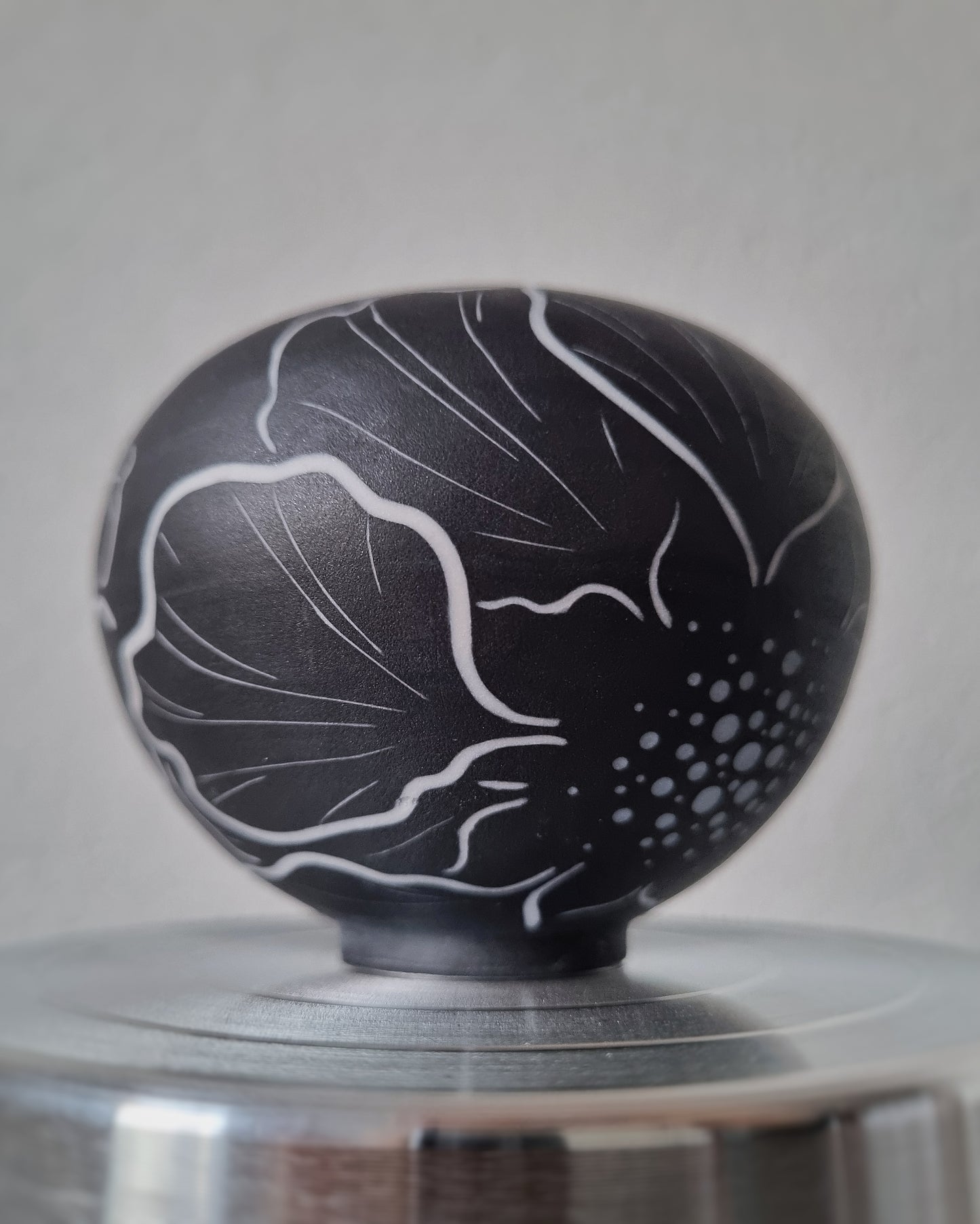 Petit vase en porcelaine noire et fleurs blanches